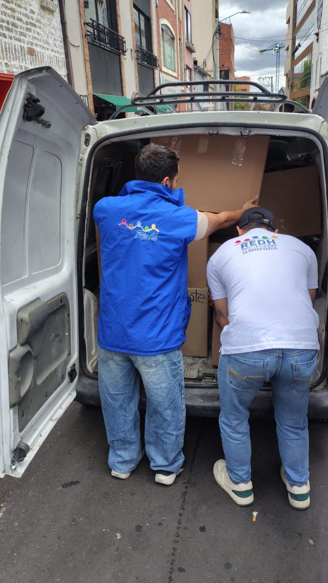 Voluntarios de REDH cargan cajas de ayuda humanitaria en una camioneta